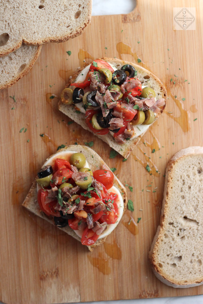 Open sandwich de queso, tomates aceitunas y anchoas